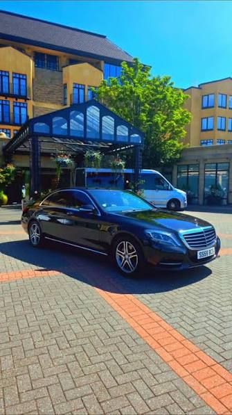Black executive car outside a hotel